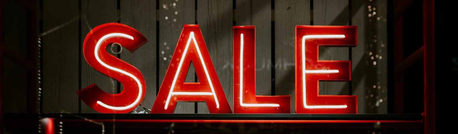 Red neon SALE sign in a shop window