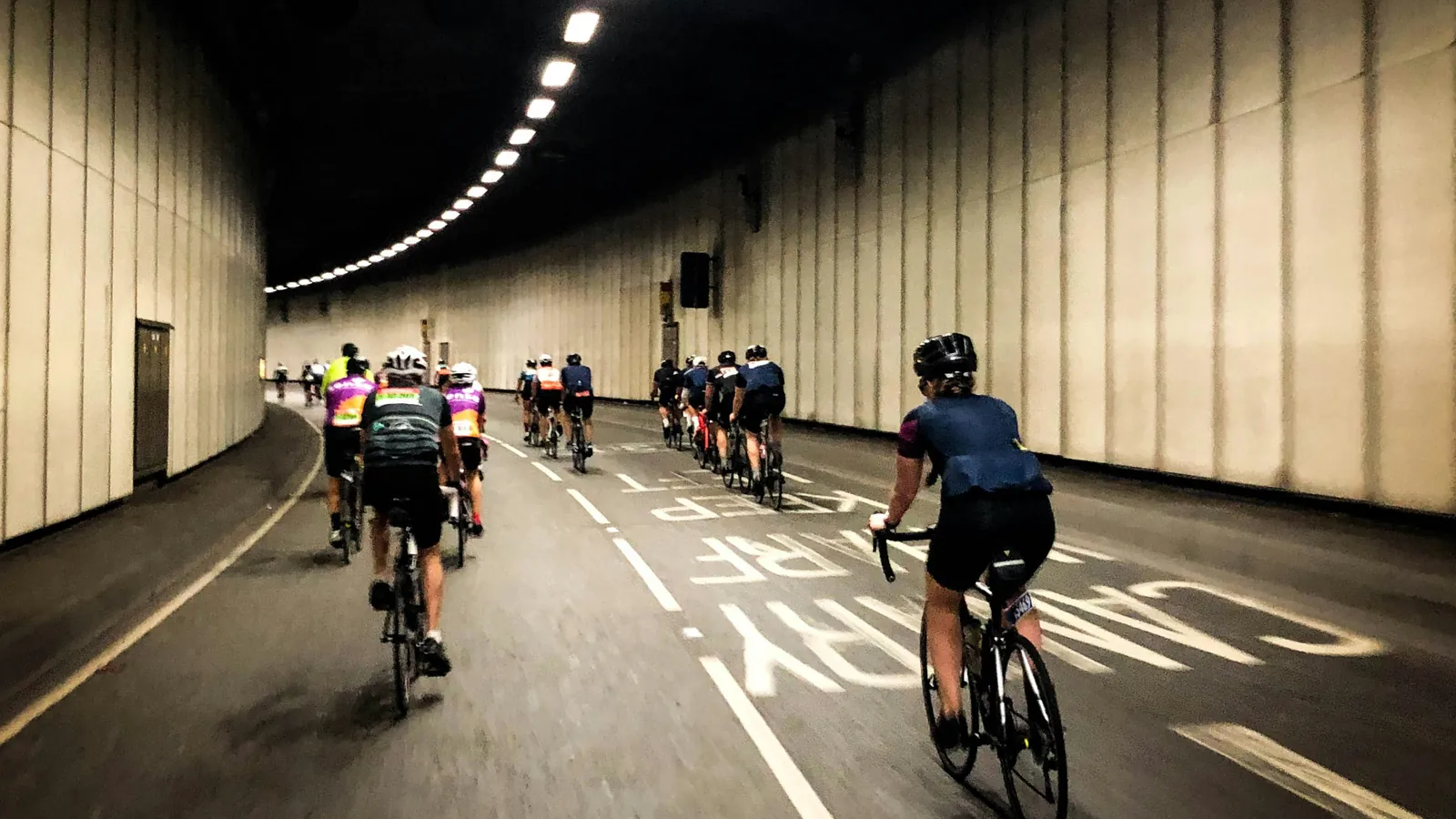 Group of cyclists riding through a tunnel